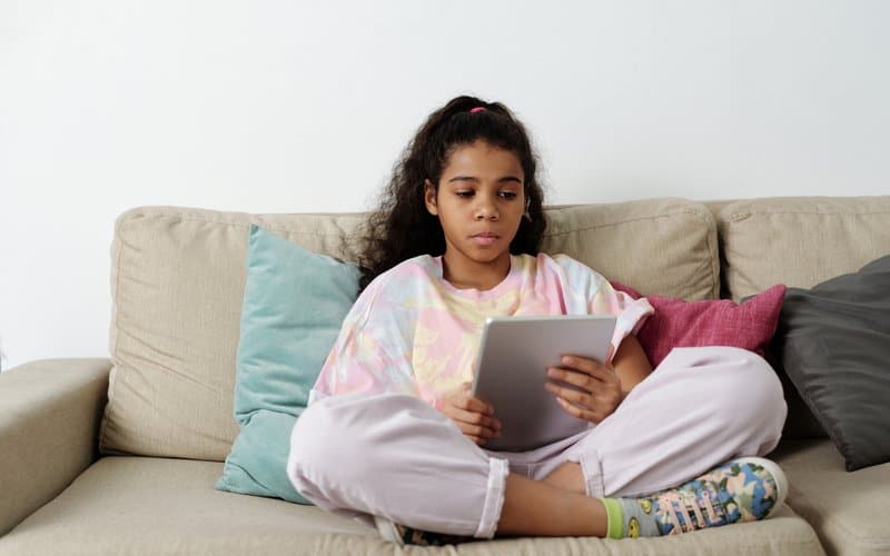 a tween girl reading a book on her kindle