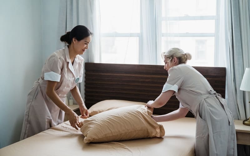 two women housekeepers making a bed