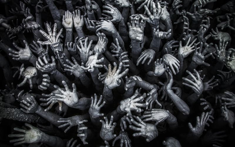 black and white photo of hands reaching up