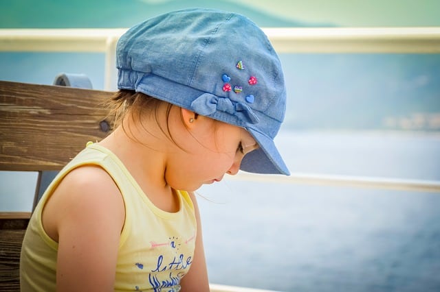 Little girl with blue hat and yellow shirt