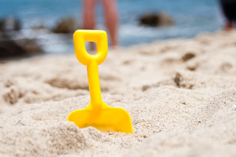 yellow shovel in the sand