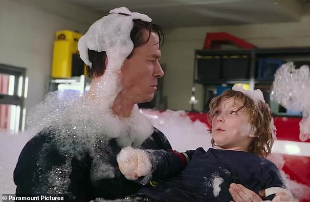 man and boy covered with soap suds in a fire house