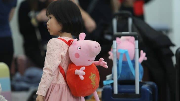 little girl wearing a peppa pig backpack