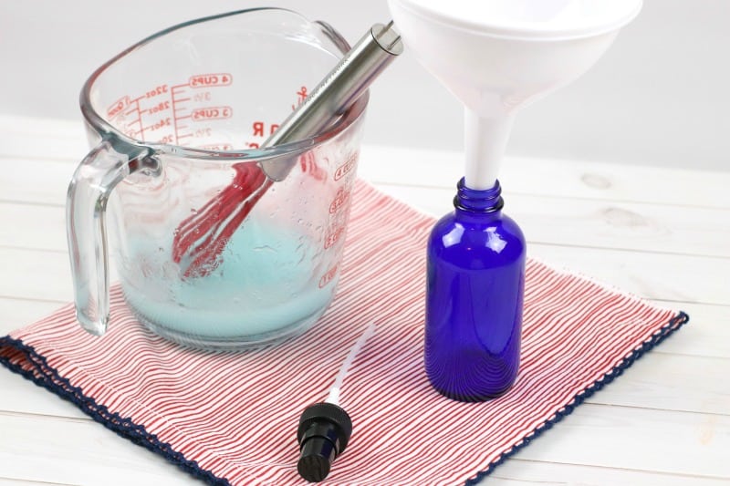 a measuring cup, funnel and blue bottle