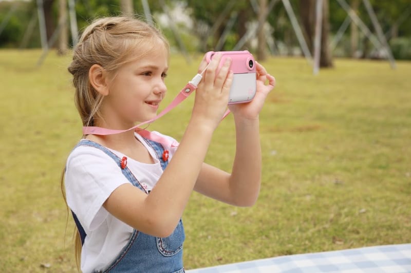 girl using a pink and white camera
