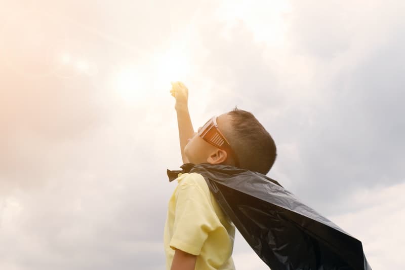 a boy wearing a superhero cape and mask