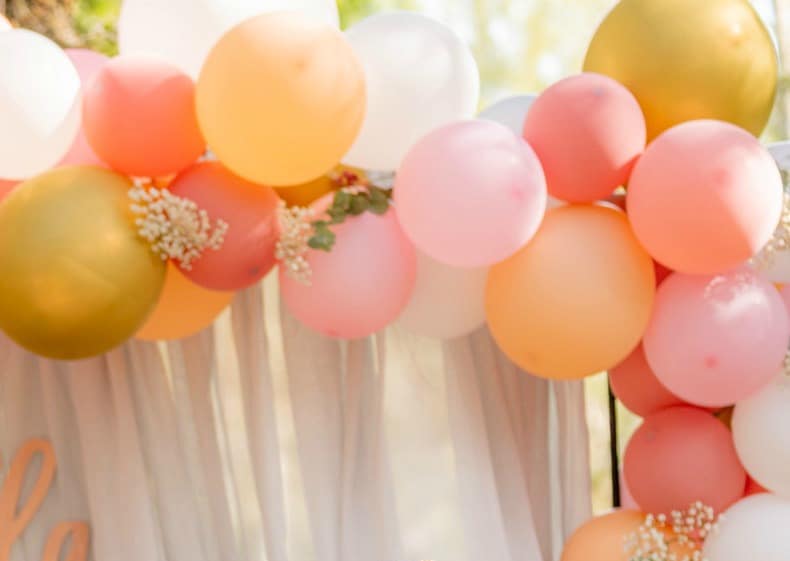 a close up shot of party decorations in pink orange and gold