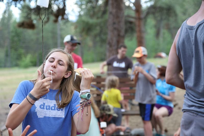 a girl licking her fingers while eating a smore