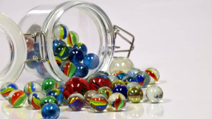 marbles spilling out of a glass jar