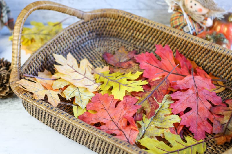 a brown basket with faux leaves