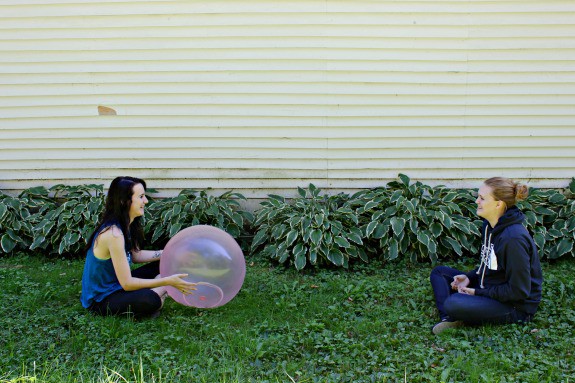 Two girls sitting in the grass playing with the best outdoor balls