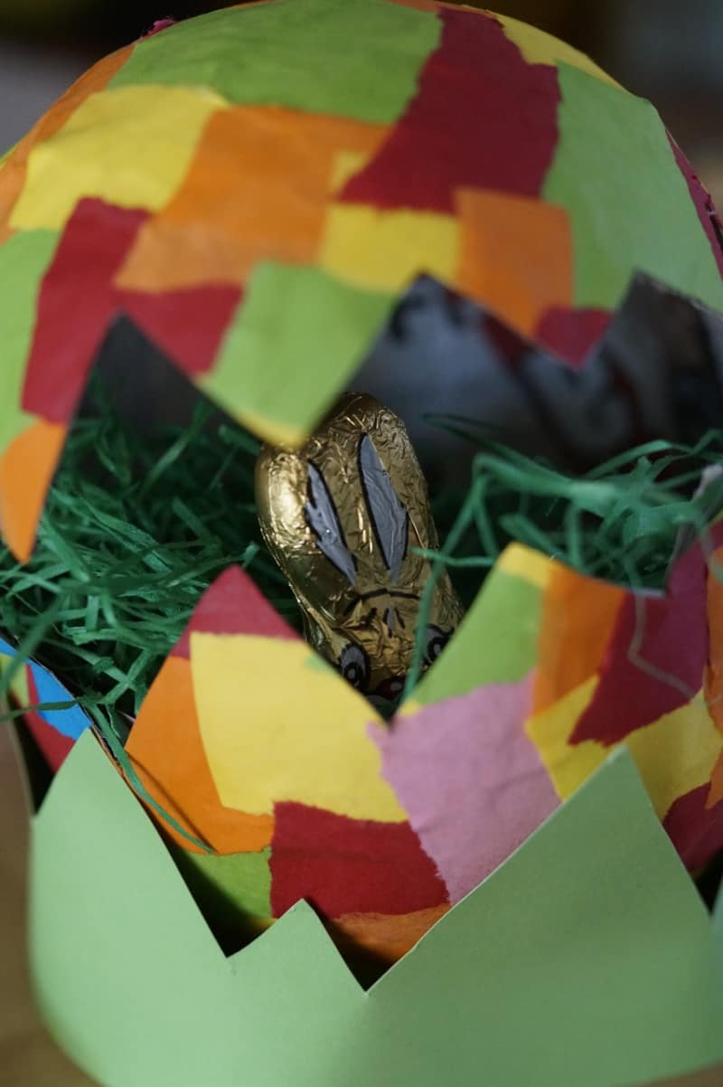 a colorful egg with Easter grass and a chocolate rabbit