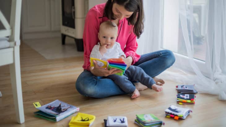 a woman holding a child reading her books