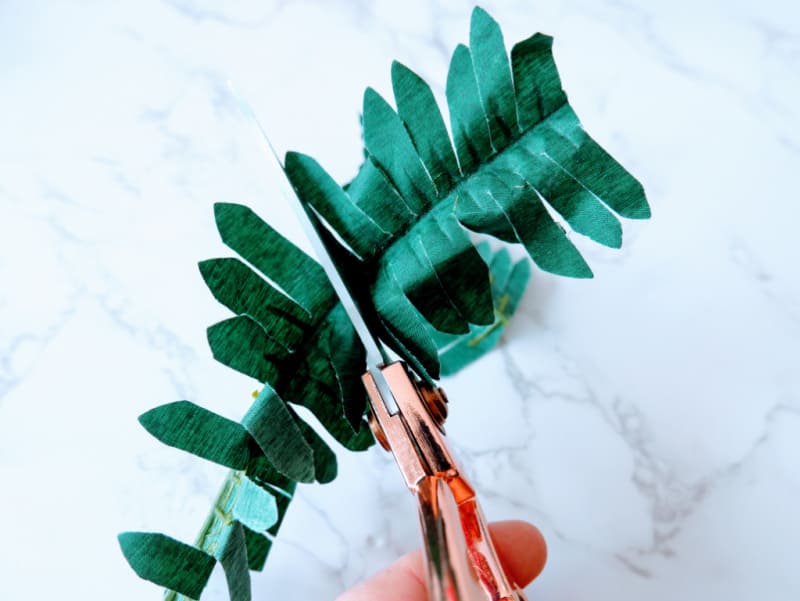 cutting faux greenery with scissors
