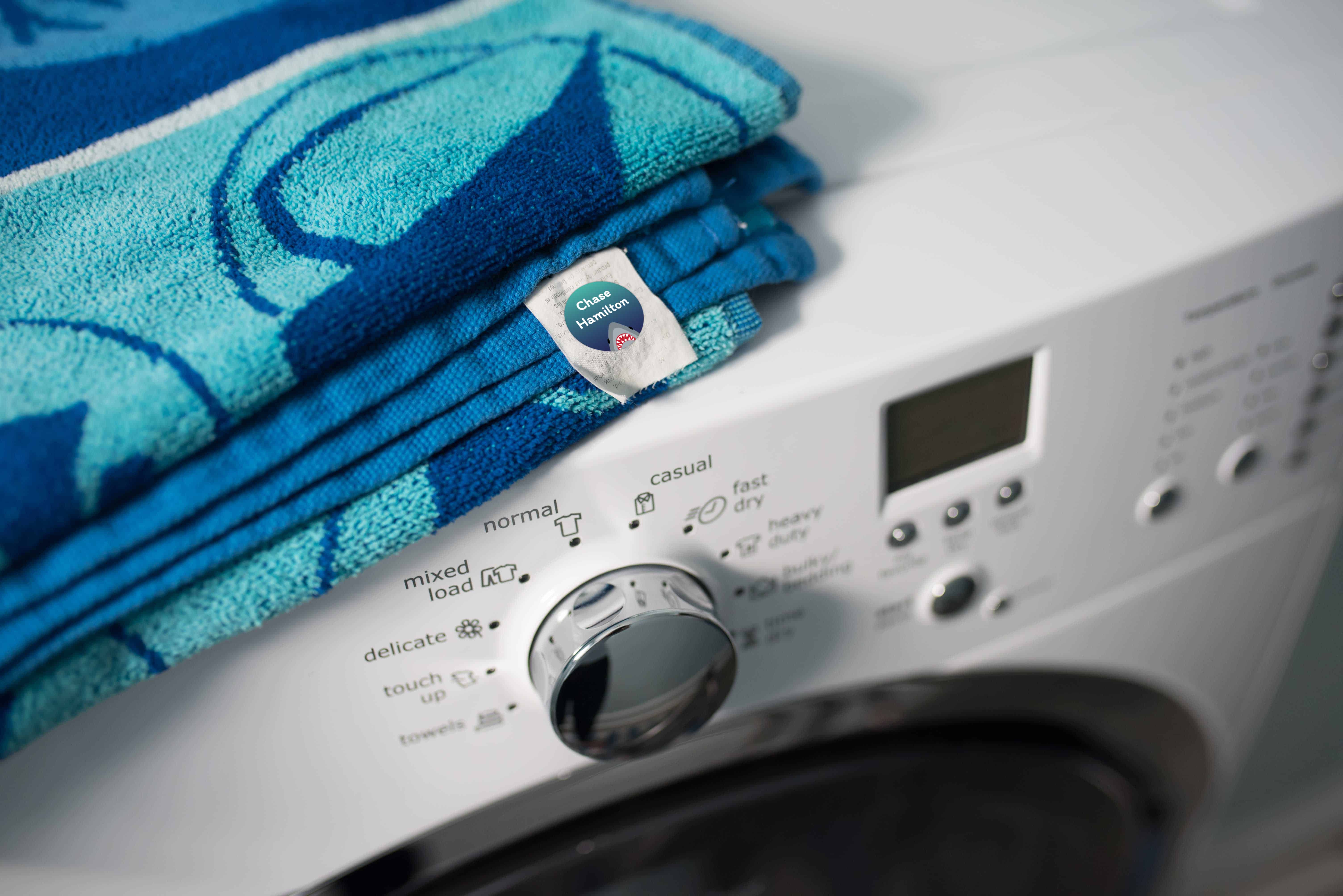 blue beach towel with a label on a white washing machine