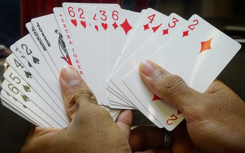two hands holding a deck of cards
