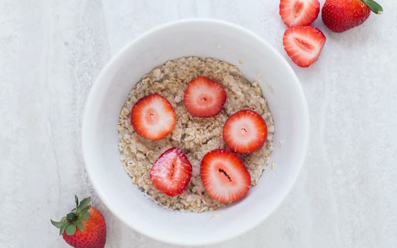 a bowl of oatmeal with fresh strawberries