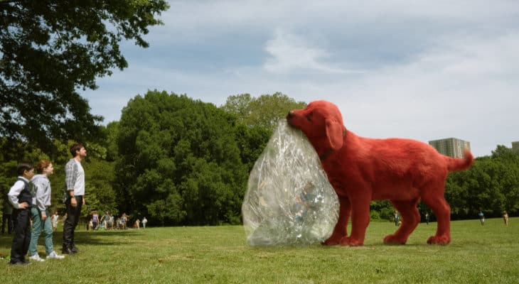 Clifford the Big Red Dog holding a deflated ball