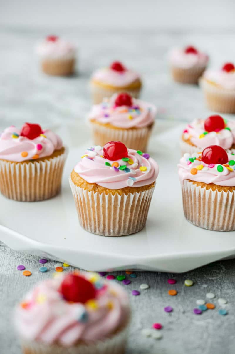 strawberry cupcakes with pink frosting and sprinkles