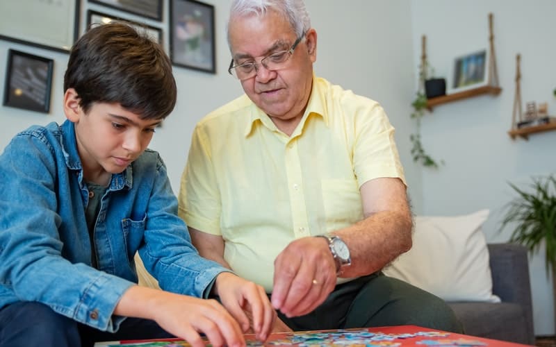 a man and child putting together a puzzle