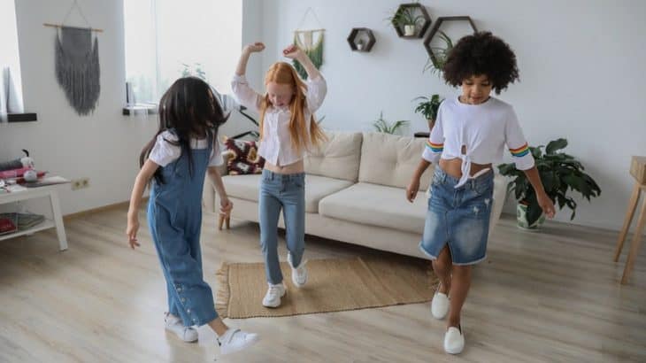 three children dancing in the living room