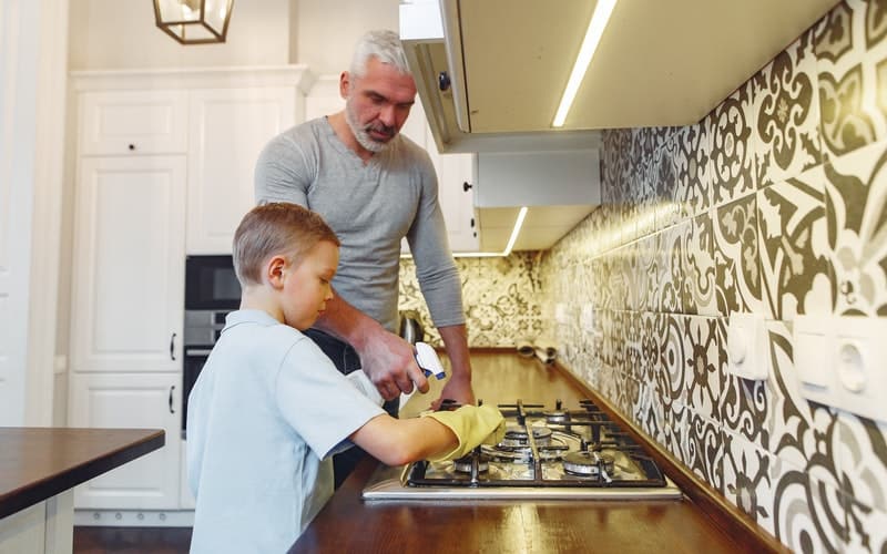 a boy and his father cleaning the stove