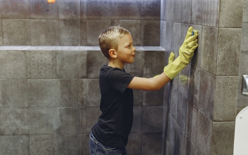 a boy washing the wall with a sponge