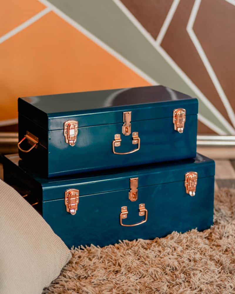 two blue trunks on a brown carpet