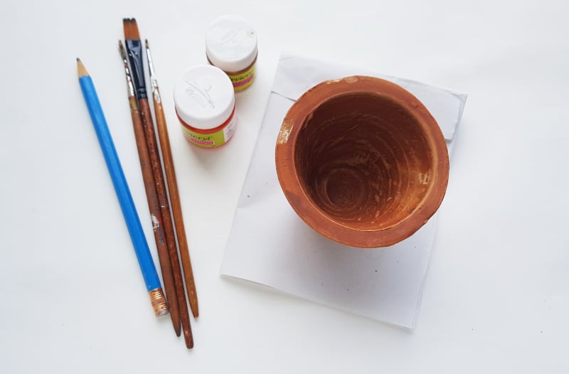 a clay pot and painting supplies