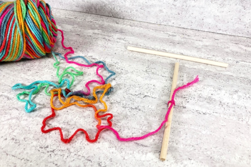 tying the yarn to the craft stick