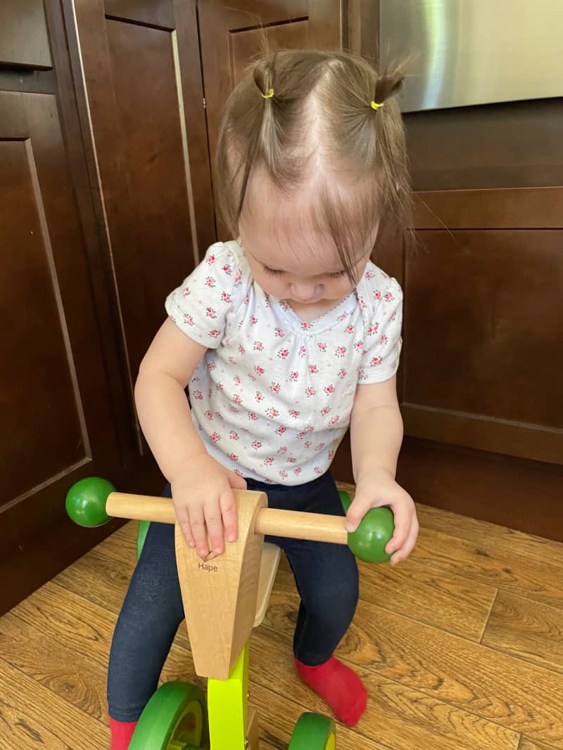 a toddler riding a balance bike