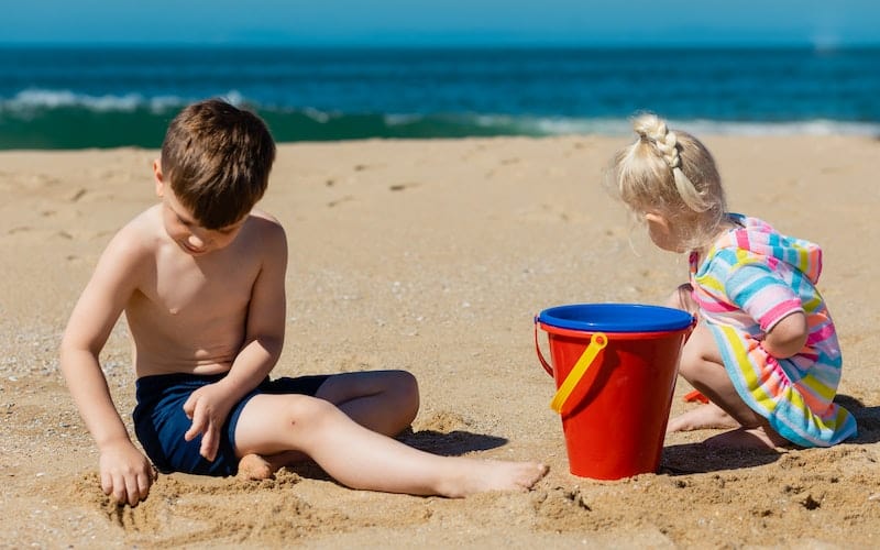 children playing in the sand at the beach