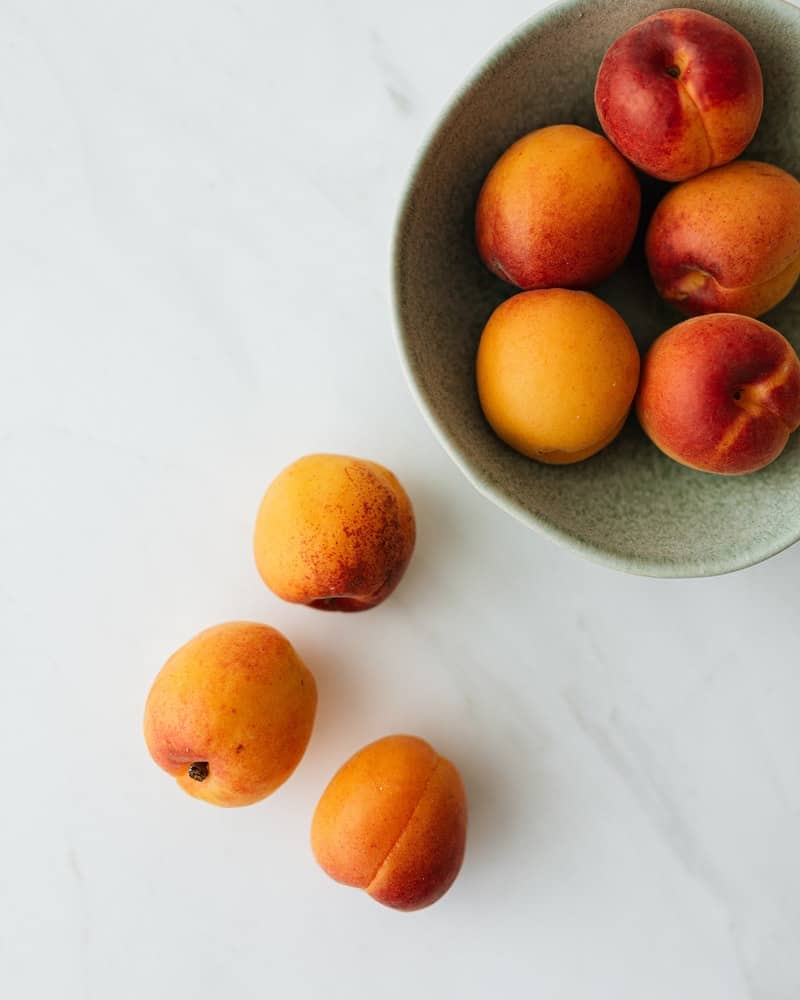 peaches in a bowl on a white background