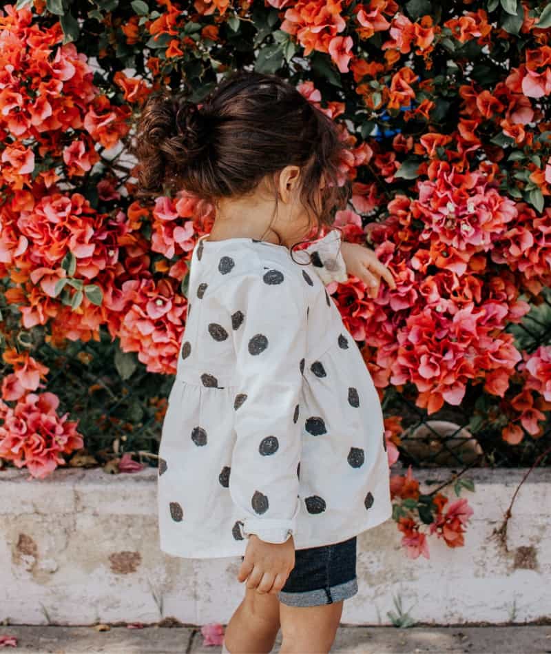 girl wearing a cute outfit near pink flowers