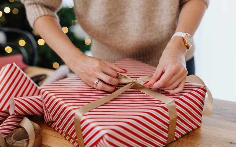 a close up of a woman wrapping a present