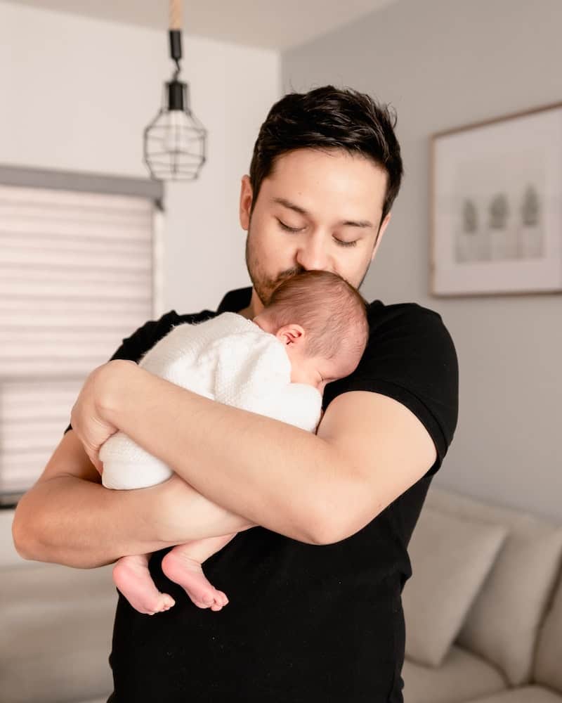 a father rocking his baby to sleep