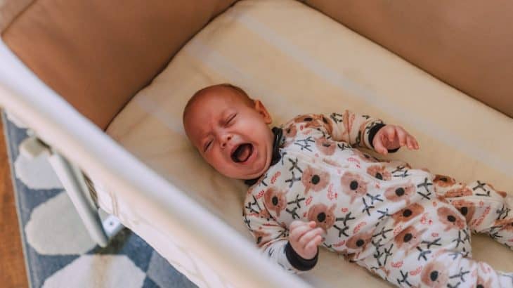 a baby crying in his crib