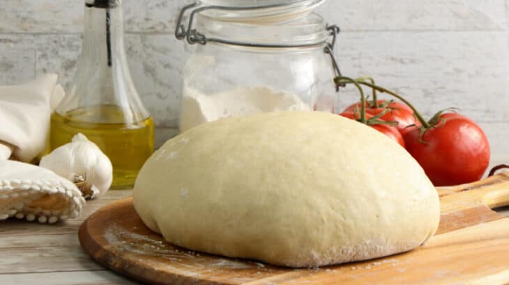 a ball of pizza dough on a cutting board
