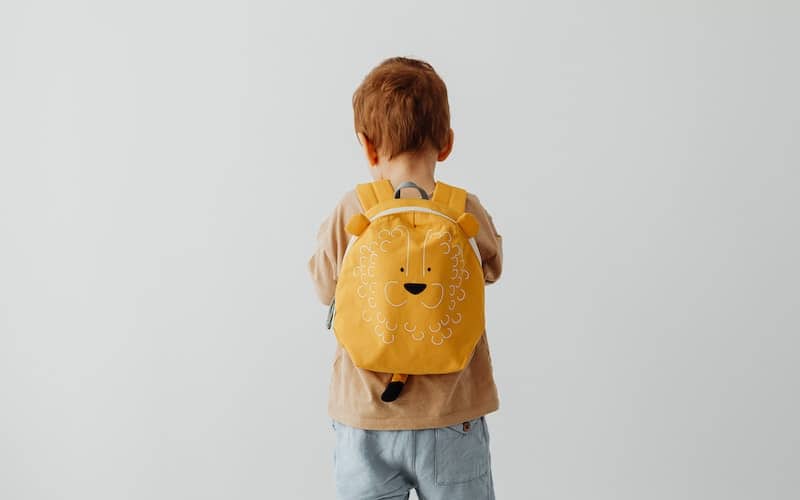 toddler with a yellow backpack