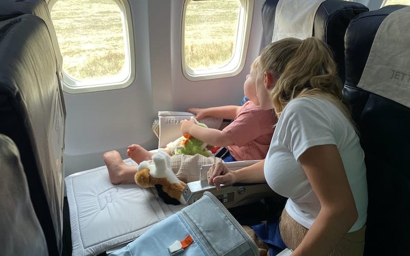mom entertaining a toddler on a plane trip