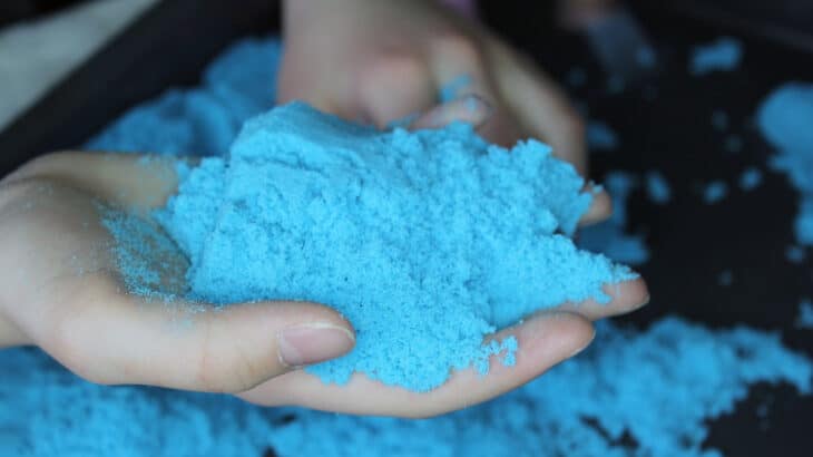 a child holding kinetic sand