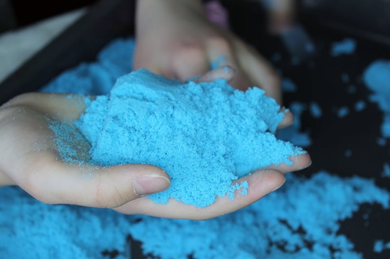 a child holding kinetic sand