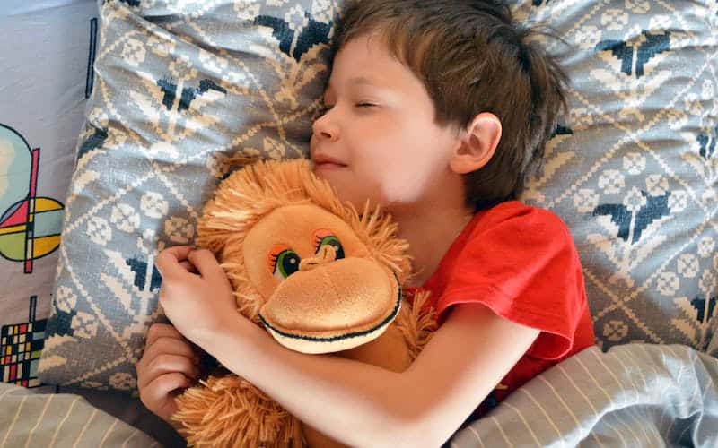 child sleeping with a plush toy