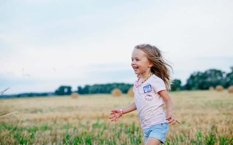happy girl child running in a field