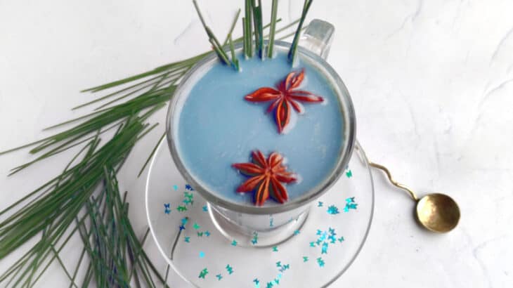 a blue milk mocktail in a tall glass