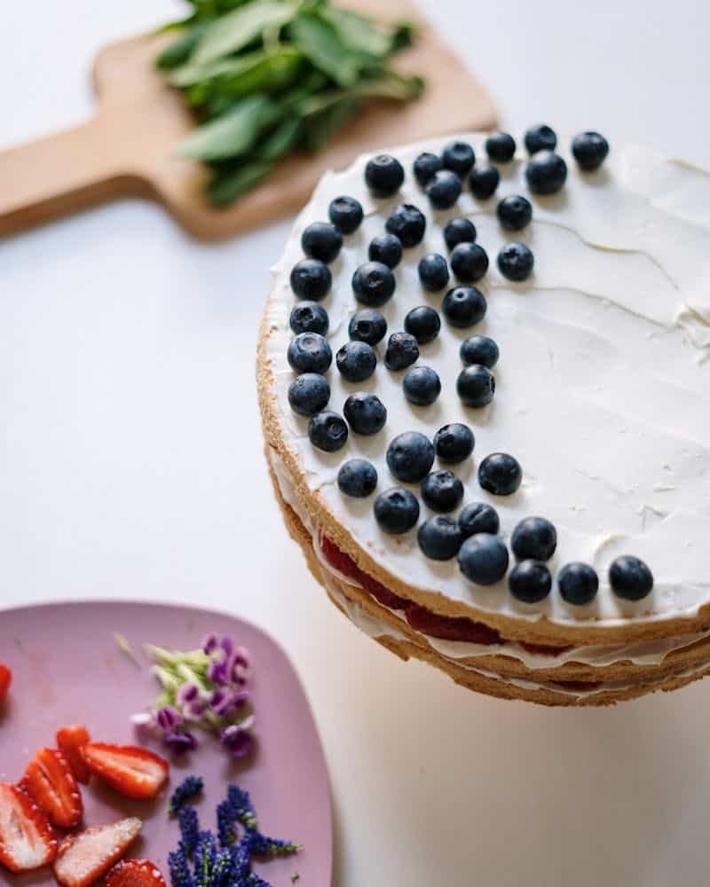 blueberries on white frosting on a cake