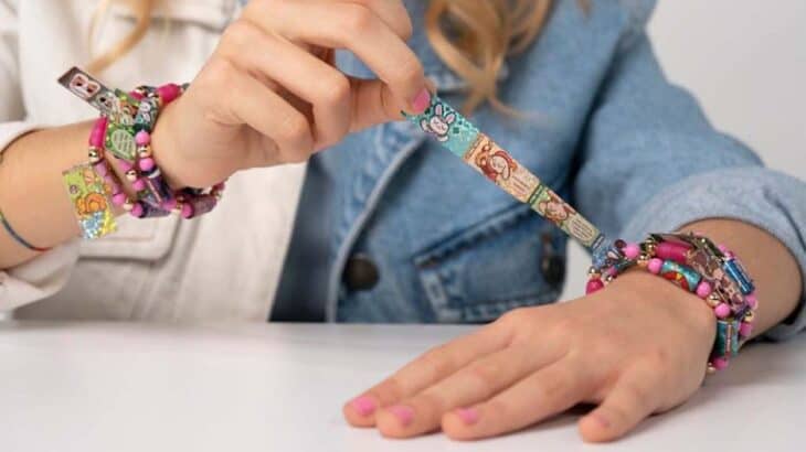 girl making friendship bracelet with stickers