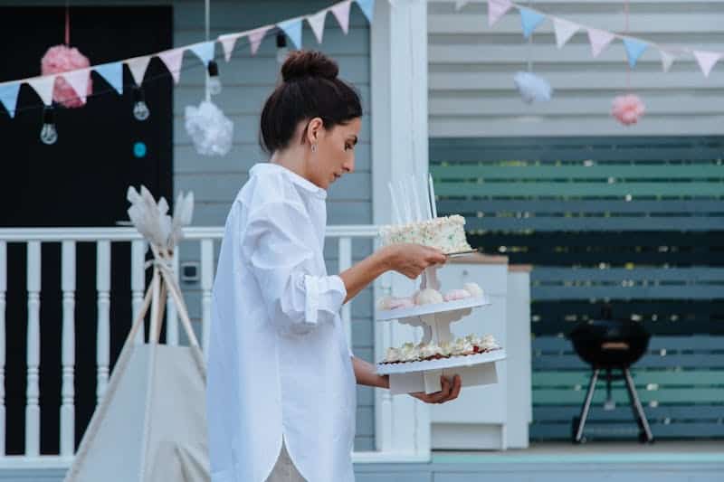 woman holding a cake display at a backyard party