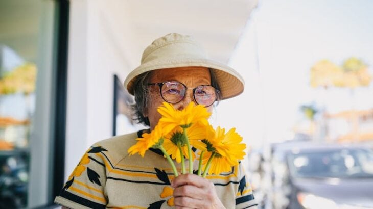 grandmother smelling flowers