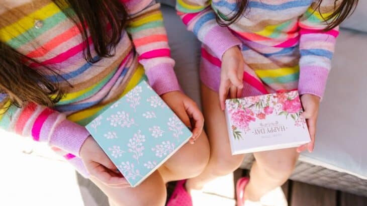 two girls holding gift cards